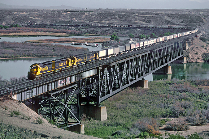 A Santa Fe “piggyback” or TOFC train crosses the Arizona-California border on the Colorado River Bridge in January 1983.